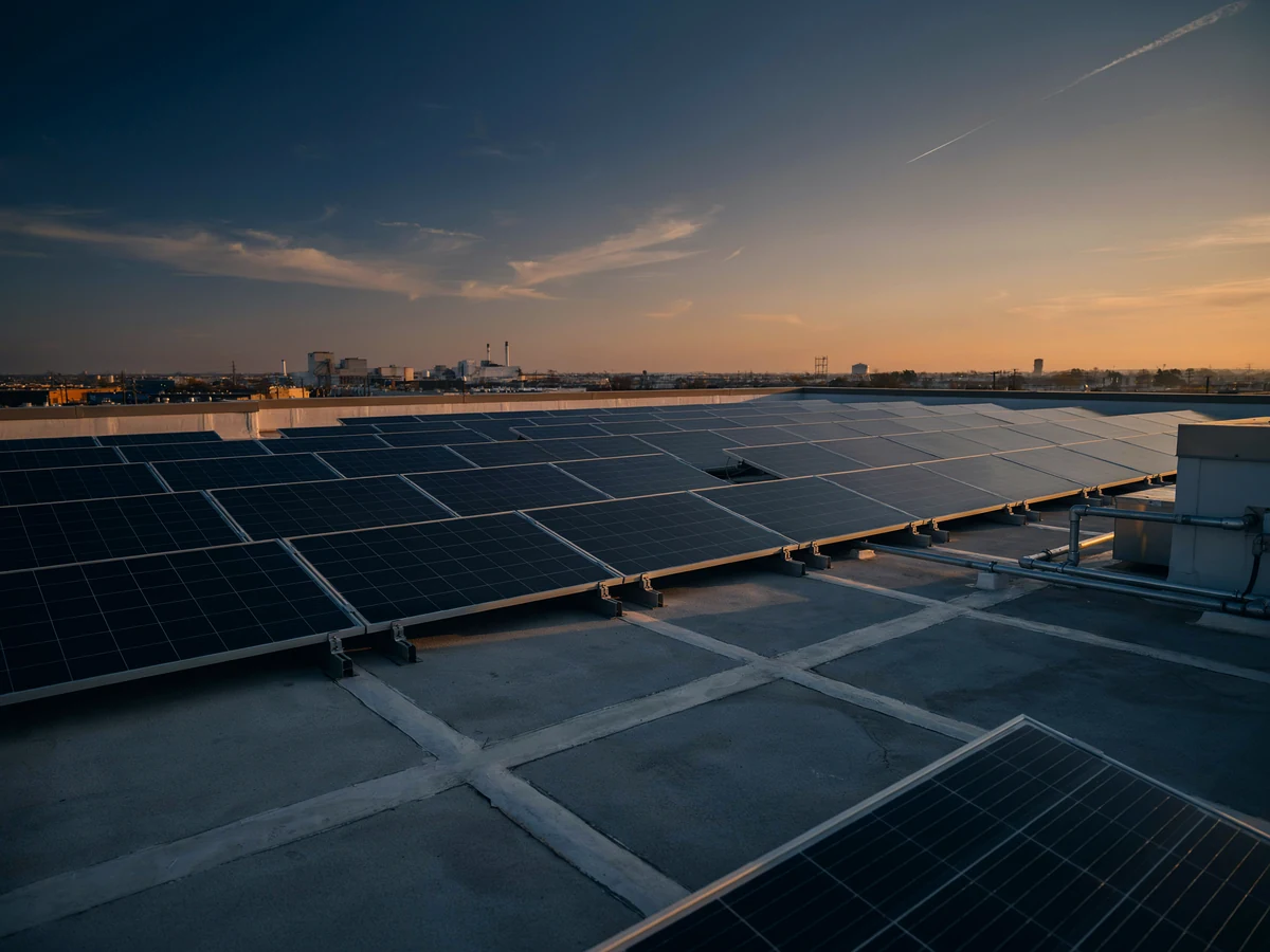 Impianto fotovoltaico sulla copertura di un edificio industriale al tramonto